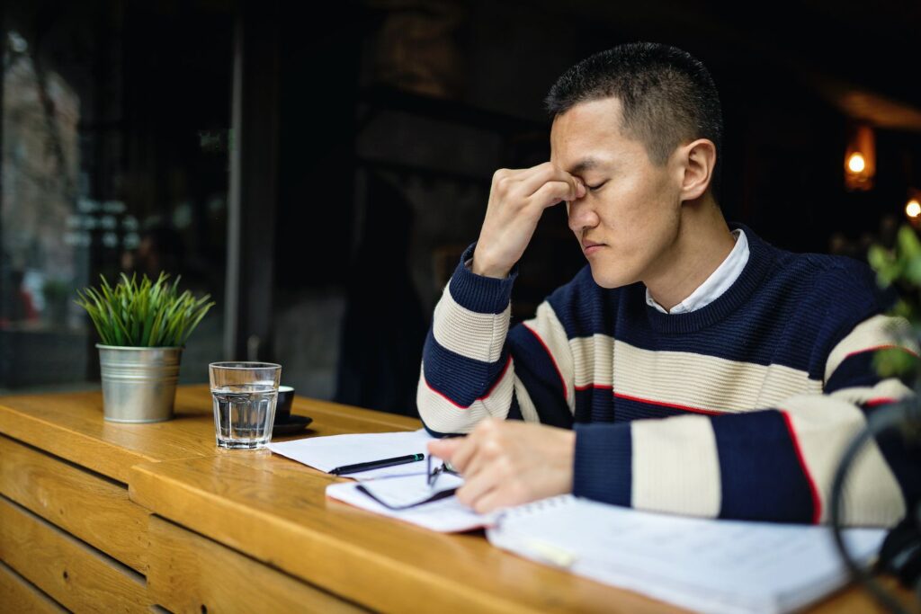 young man holding the bridge of his nose indicating a headache TMJ treatment dentist in Columbia Maryland